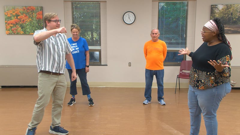 Improv class participants perform a scene together.