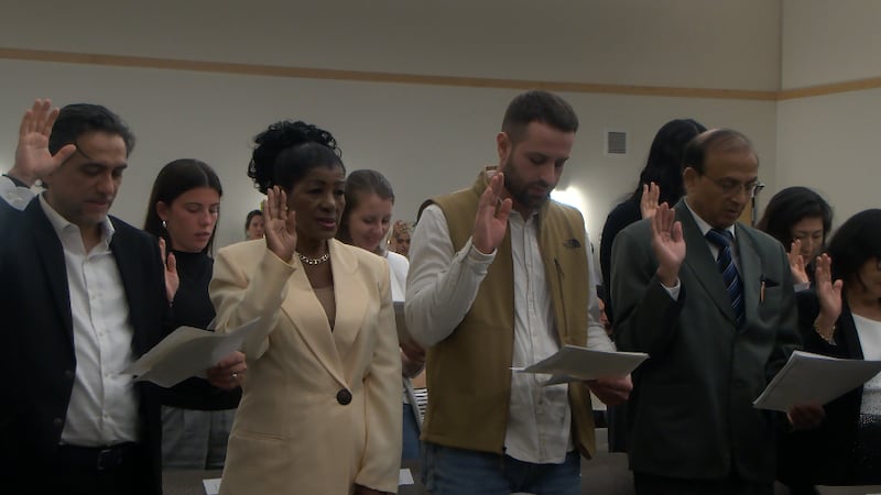 New naturalized citizens take their oath before a judge at the Peoria Public Library