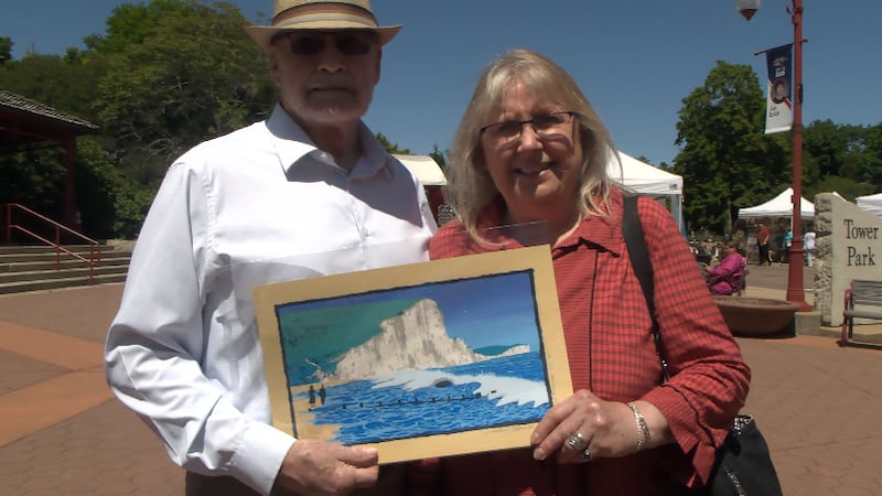 Peoria Heights residents Elvira Brooks and Kent Beavins show off artwork they bought at the...